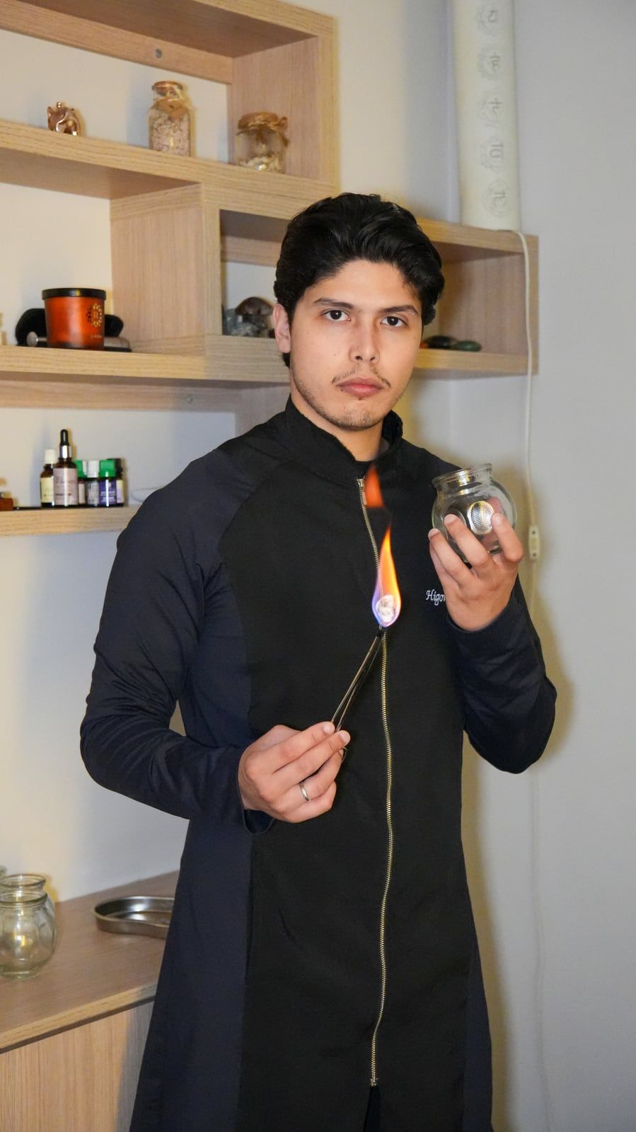 Higor Couto segurando uma ventosa de vidro e a chama usada para prepará-la